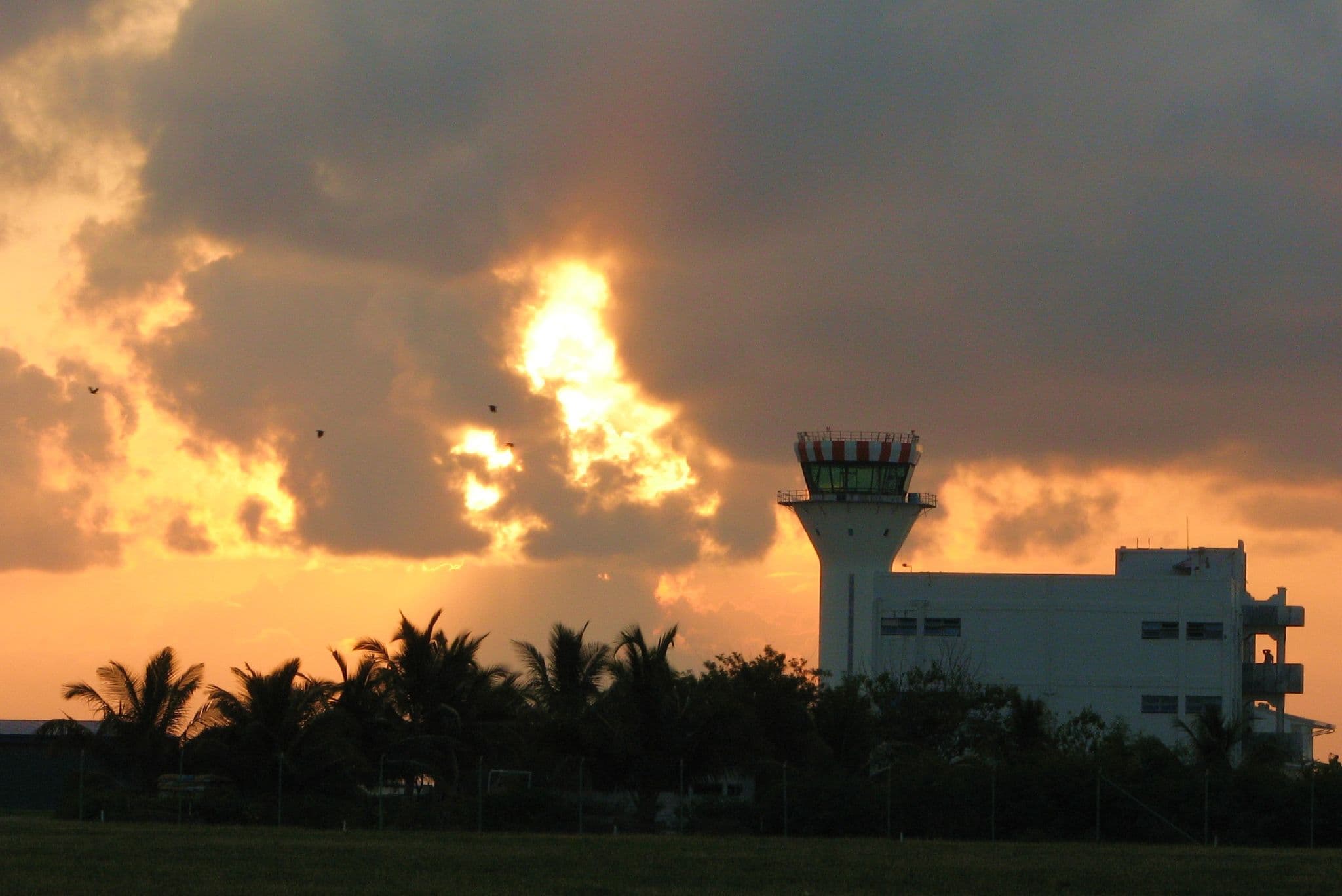 Air traffic control tower silhouetted at sunrise